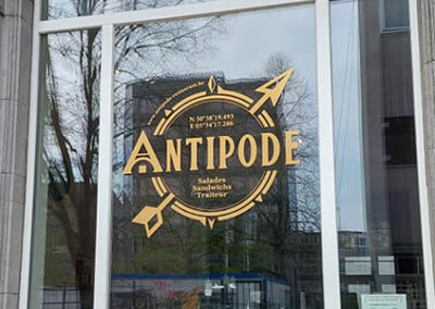 Lettrage sur vitrine réalisé par Kimva (impression, lettrage, graphisme et signalétique à Liège) pour le restaurant Antipode.
